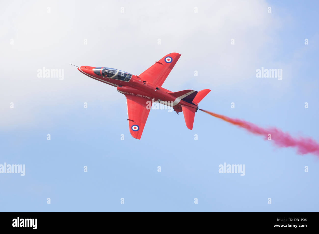 Single RAF Red Arrow Hawk displaying with smoke. Stock Photo