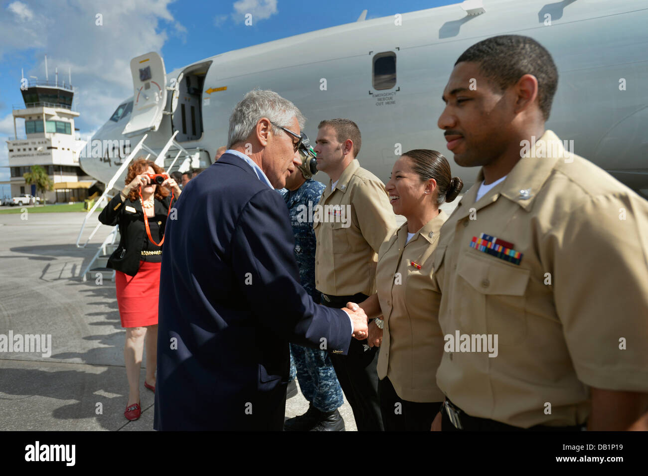 Secretary of Defense Chuck Hagel hands out coins to U.S. Sailors assigned to his motorcade before boarding a P-8 Poseidon aircraft to depart Naval Air Station Jacksonville, Fla., July 16, 2013. Hagel was on a three-day trip to visit several installations Stock Photo