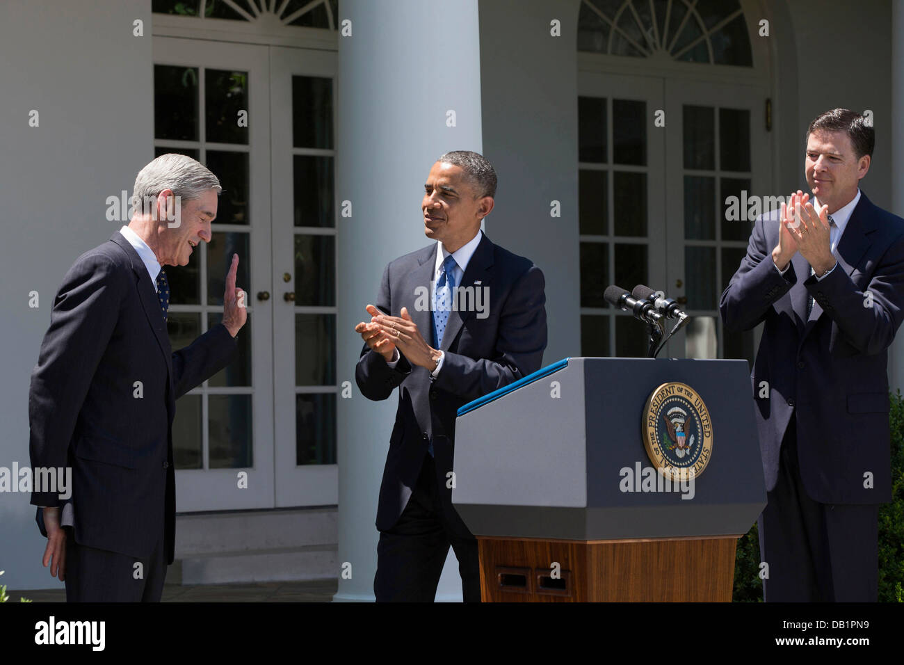 US FBI Director Robert Mueller acknowledges applause during President Barack Obama's remarks in the Rose Garden of the White House June 21, 2013 in Washington, DC. The President announced James Comey, right, as his nominee to succeed Mueller. Stock Photo