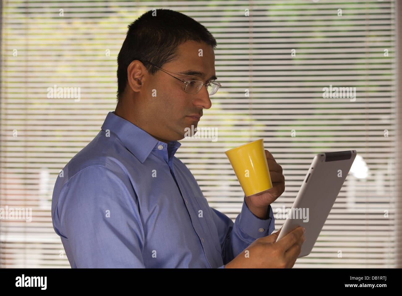 man reading ipad and drinking coffee Stock Photo