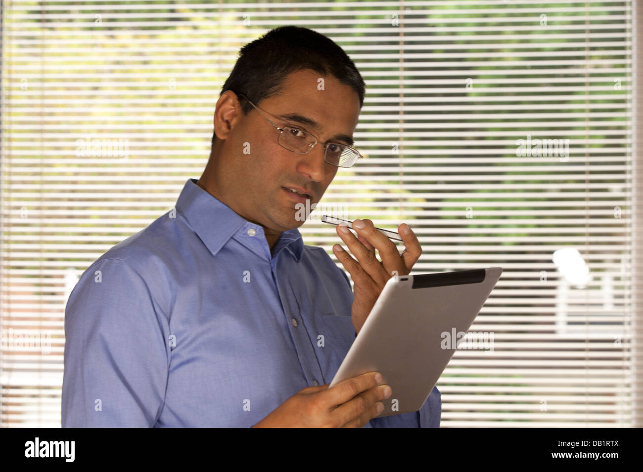 man talking on phone holding ipad Stock Photo