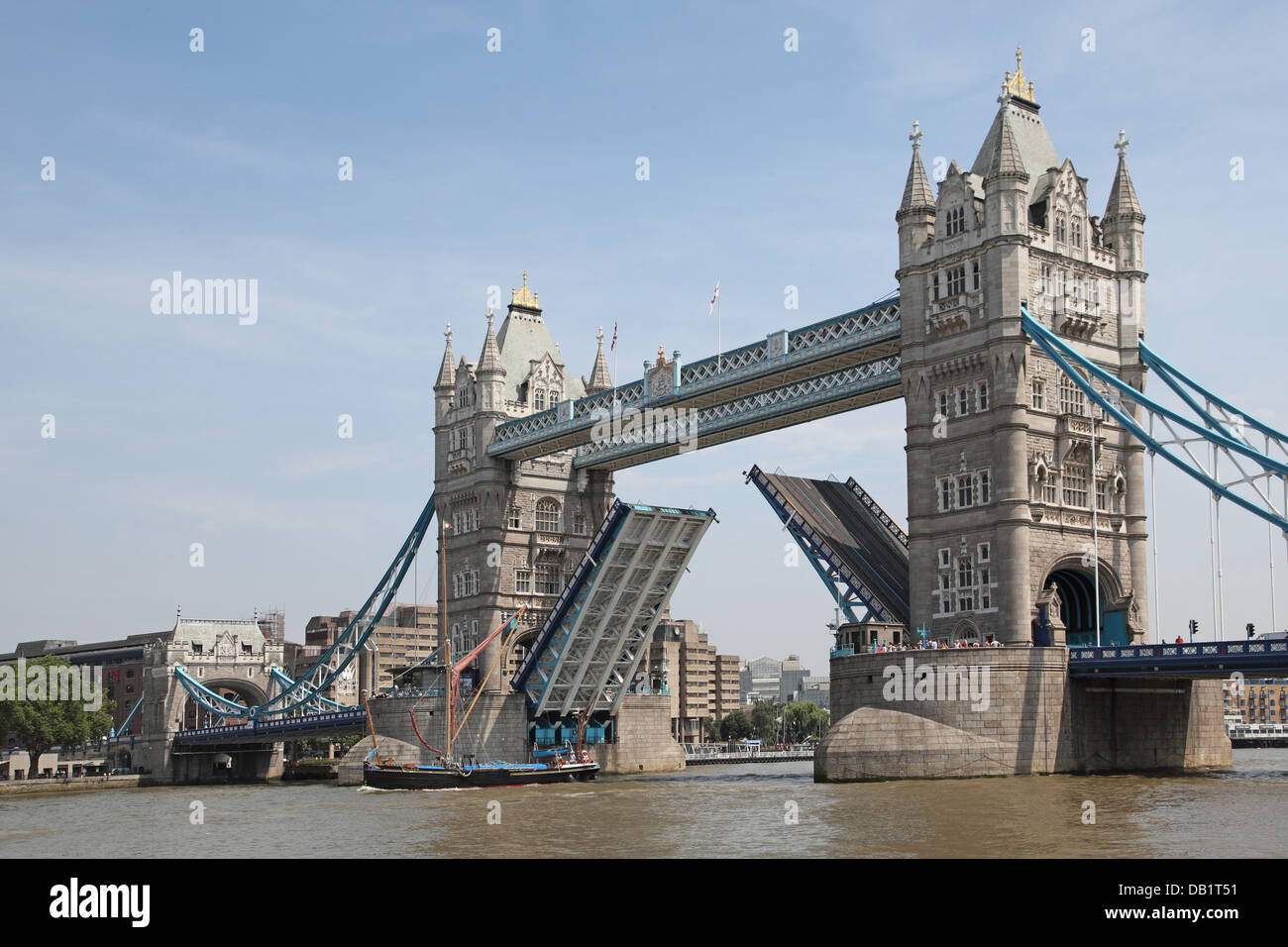 Tower Bridge opens to allow a sailing barge to pass beneath ...