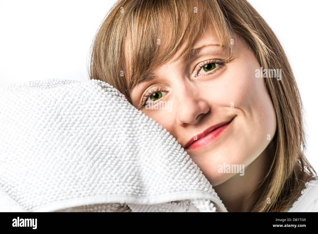 Portrait of a young girl with green eyes set, snuggled in a white towel, isolated on white background Stock Photo