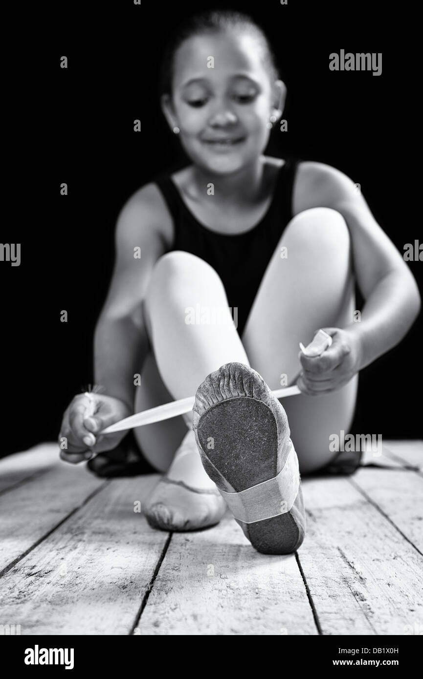 Young ballerina girl in a low key studio. More poses available. Stock Photo