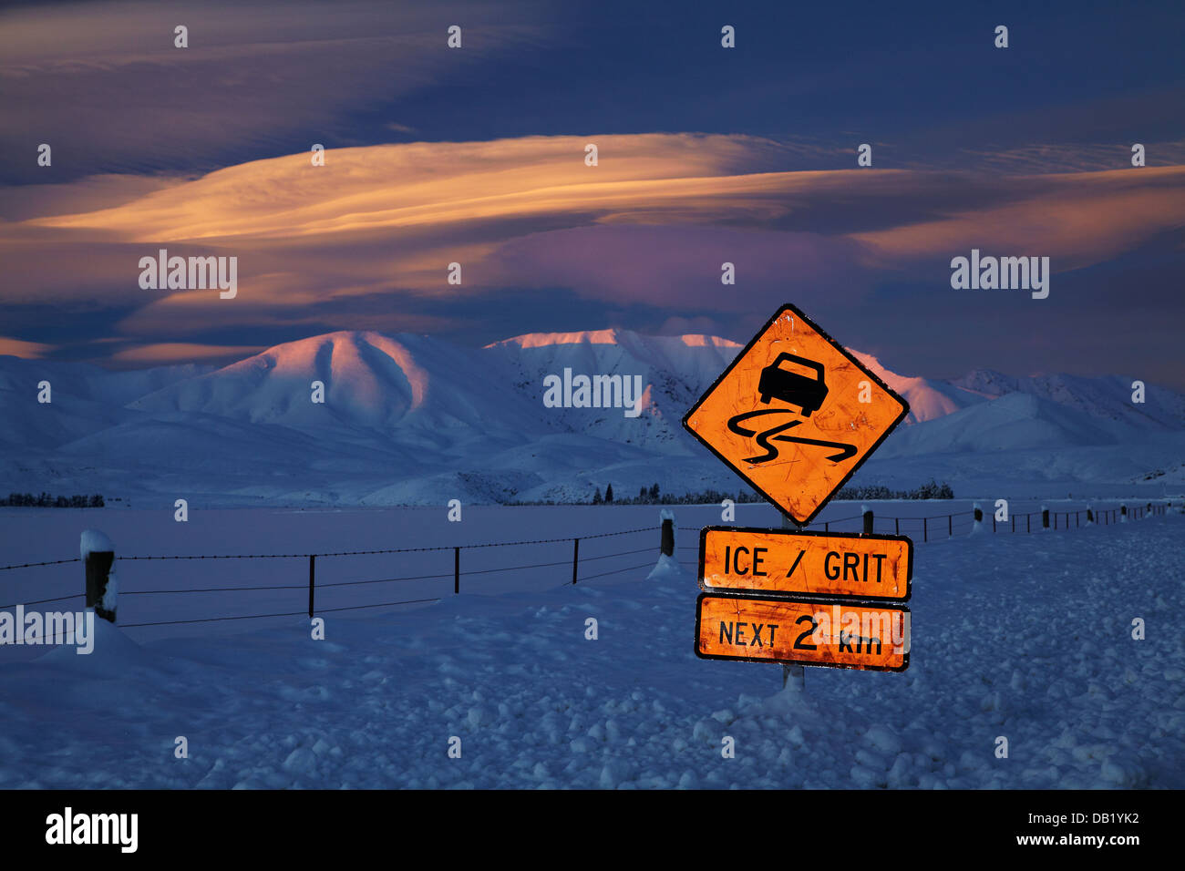 Icy road warning sign and alpenglow on Hawkdun Range, and lenticular
