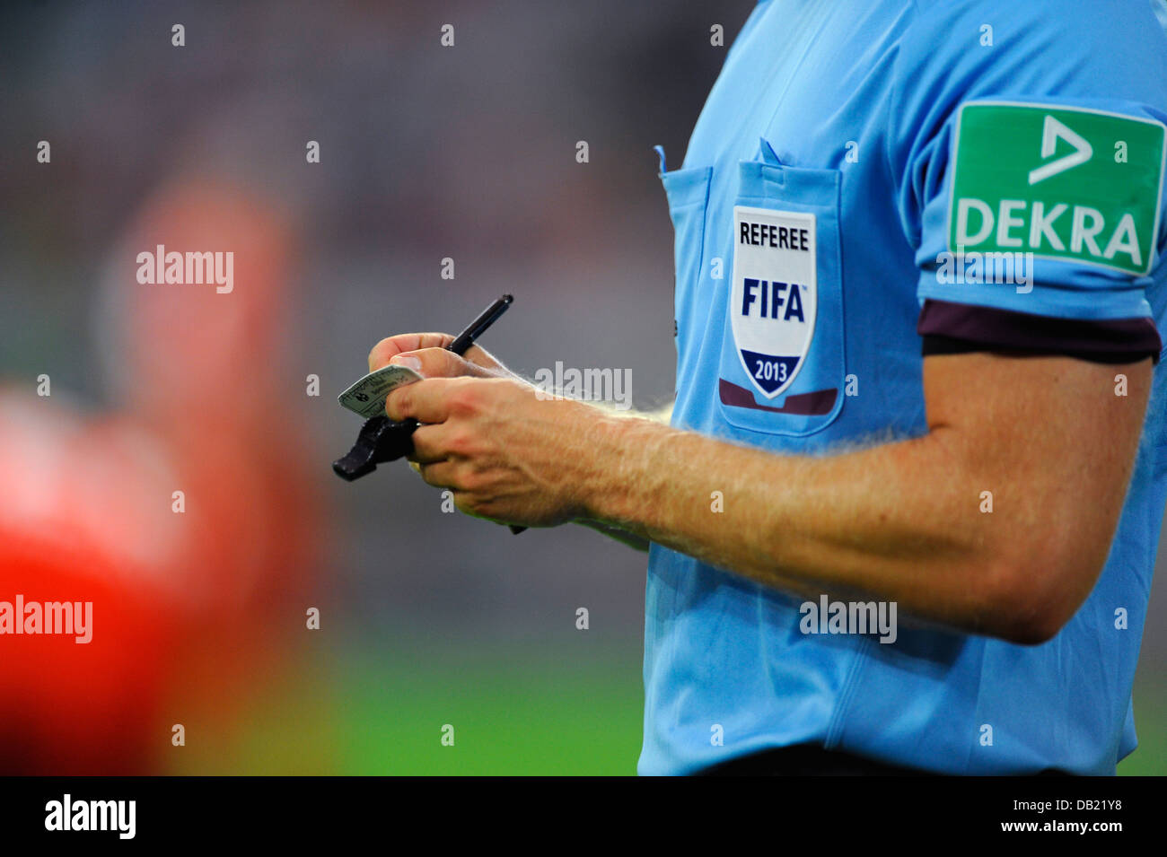 FIFA football referee notes a players name on his notepad Stock Photo