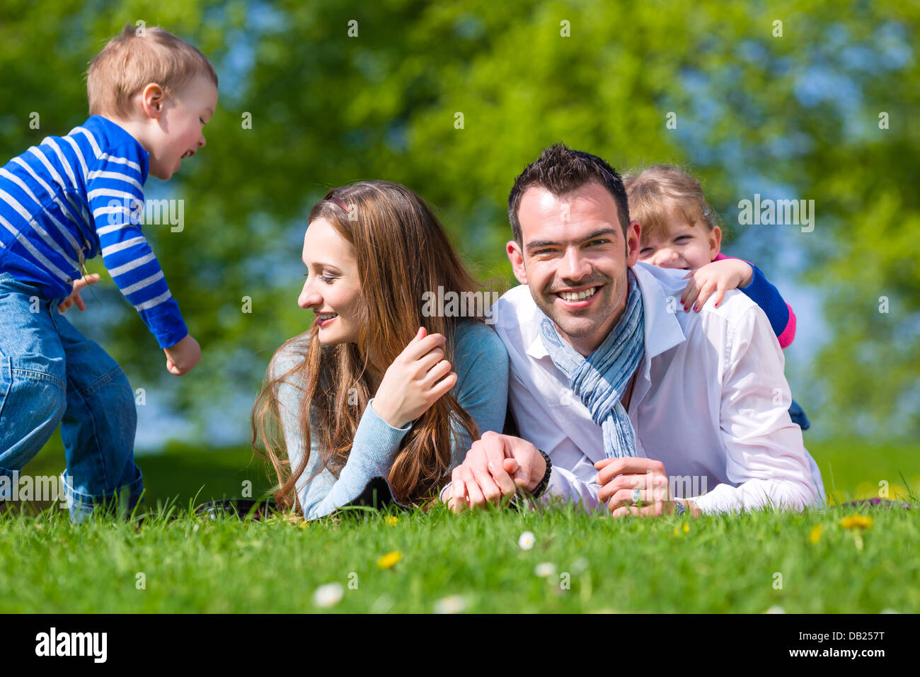 Happy family with daughter and son sitting in a meadow in summer Stock Photo