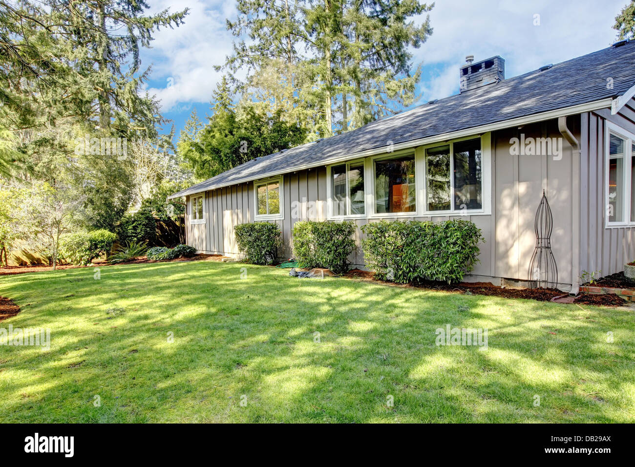 Brown grey house exterior with spring backyard Stock Photo - Alamy