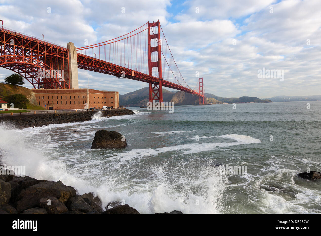 Scenic view of the Golden Gate Bridge in San Francisco with the ocean beating against the rocks Stock Photo