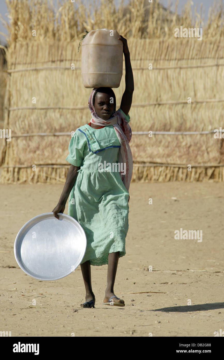 A Sudanese woman carries a water canister on her head in Mukjar in Western Dafur, Sudan, 09 December 2007. Photo: Peter Steffen Stock Photo