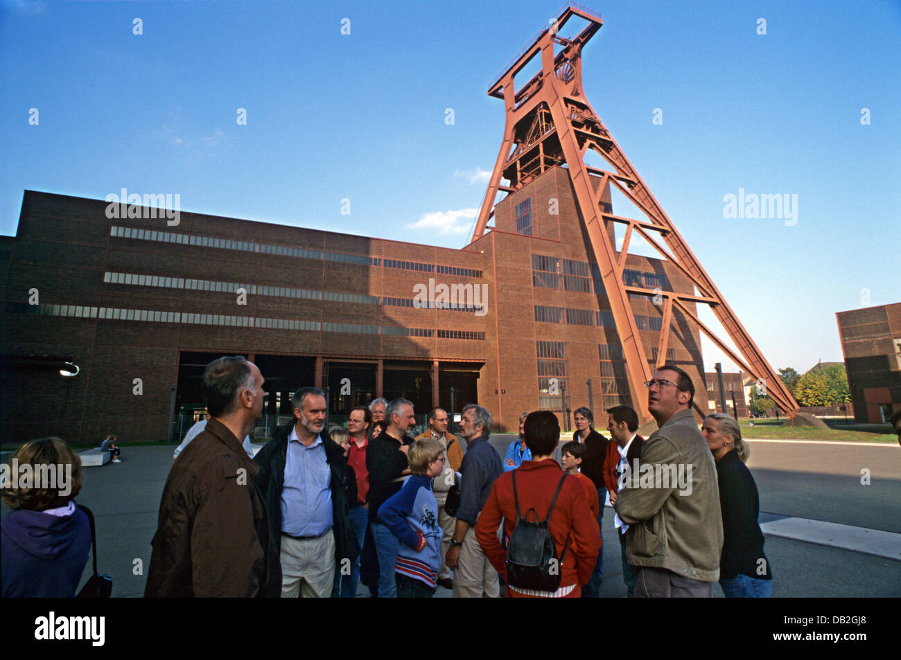 A group of tourists stands next to the hoist construction of shaft XII on the premises of 'Zollverein' Coal Mine Industrial Complex in Essen, Germany, 08 October 2007. The landmark structure and its surrounding buildings were designed by architects Fritz Schupp and Martin Kremmer in the 1920s and built within four years as of 1928. The historical coal-mining site was inscribed as U Stock Photo