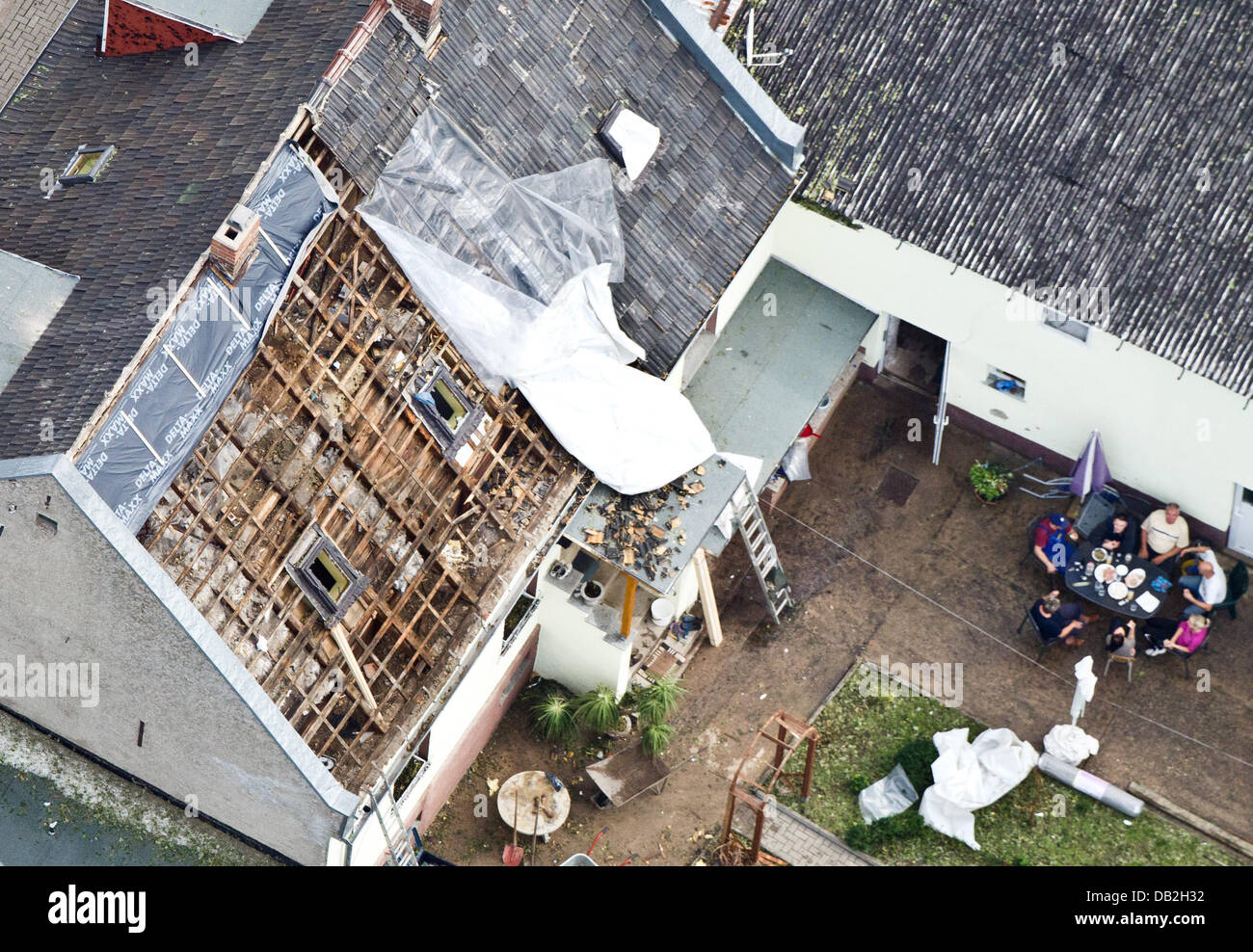 Clearing operations are underway on the rooves of houses in Coermigk, Germany, 12 September 2011. Several people received minor injuries in Saxony-Anhalt the day before during strong storms with hail, heavy rain, and mudslides. In the region of Bernburg, one of the most affected areas, the city administration estimates damages at around 70 million euros. Approximately 700 houses we Stock Photo