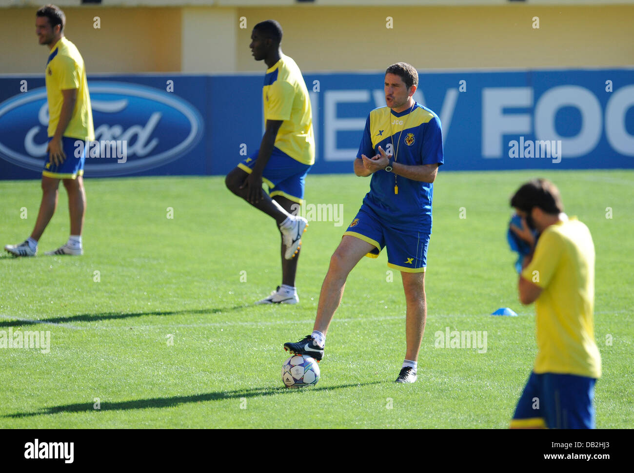 Coach of the Spanish soccer team Villarreal CF Juan Carlos Garrido (2-R) claps his hands during a training session of his team at the El Madrigal stadium in Villarreal, Germany, 13 September 2011. Villarreal faces Bayern Munich for the first Champions League group match on 14 September 2011. Photo: Andreas Gebert Stock Photo