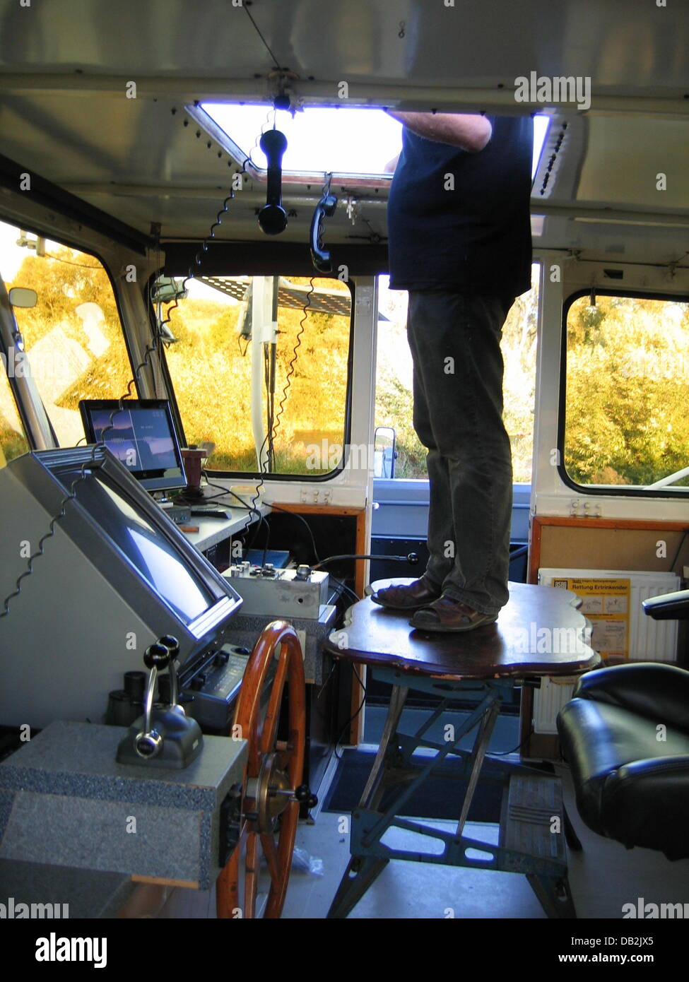A police photo from 14 September 2011 shows a ship captain standing on a table on the navigation cabin of the ship on the Main close to Wuerzburg, Germany. The captain navigated his ship with his feet and at times did not have any sight of the river. According to the police, the 60-year-old had stored his freight in such a way that it blocked his sight from the front window. To sol Stock Photo