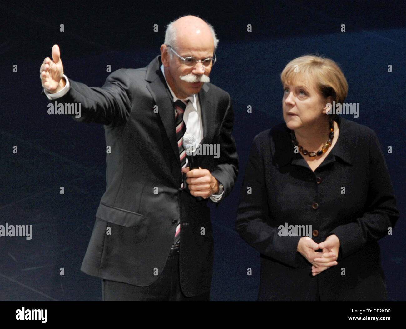 Dieter Zetsche (L), chairman of Daimler, speaks to German chancellor Angela Merkel inside the hall of Mercedes-Benz at the International Motor Show IAA in Frankfurt Main, Germany, 15 September 2011. From 15 to 25 September 2011 exhibitors from all over the world will present new trends of the automotive industry, headed by electronic mobility and hybrid vehicles. Photo: ARNE DEDERT Stock Photo