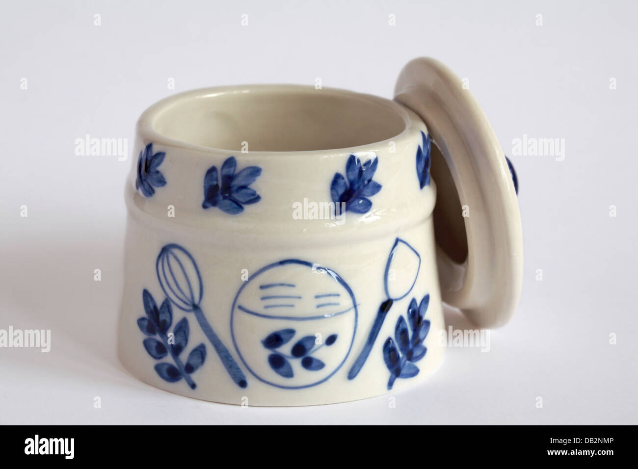 White and blue ceramic pot with lid off and resting by the side