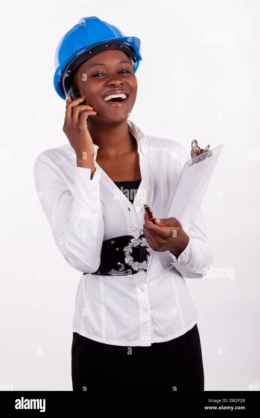 Young female engineer or architect speaking on her phone with a smile. Stock Photo