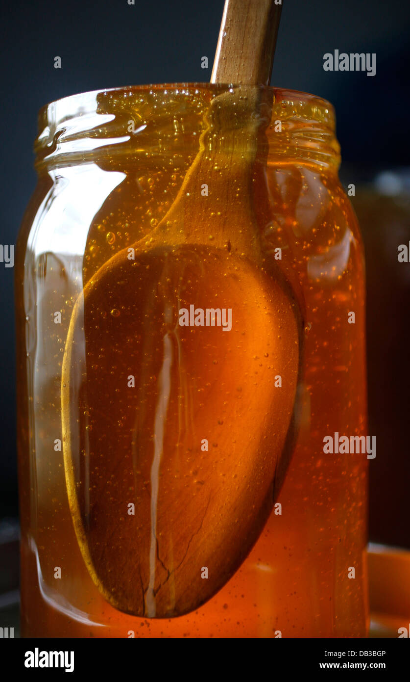 A honey pot with a wooden spoon inside is displayed in Puremiel, a