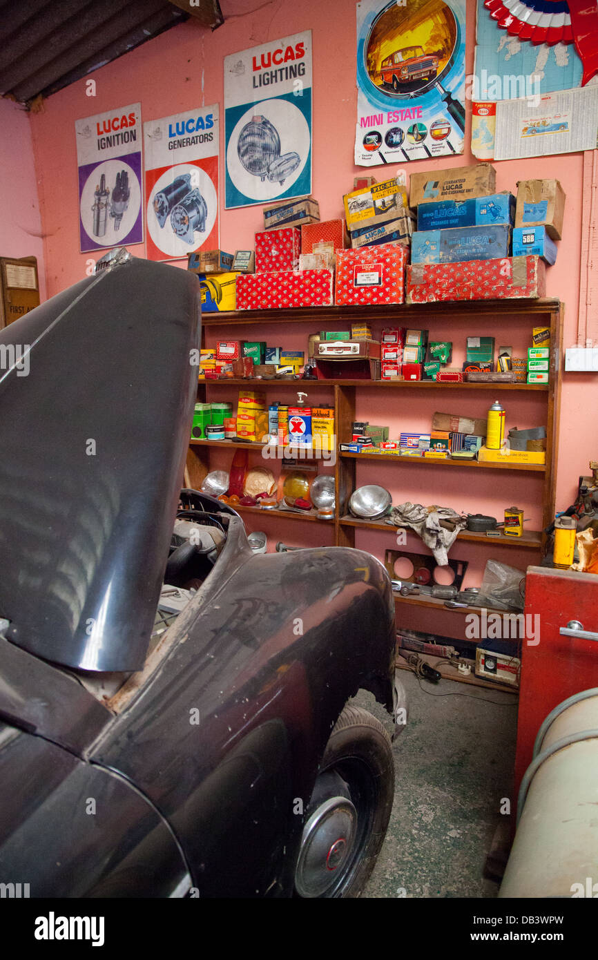 Interior of a vintage garage with car & spares in original packaging and signs / posters in Cae Dai 1950 Museum, Denbigh Stock Photo