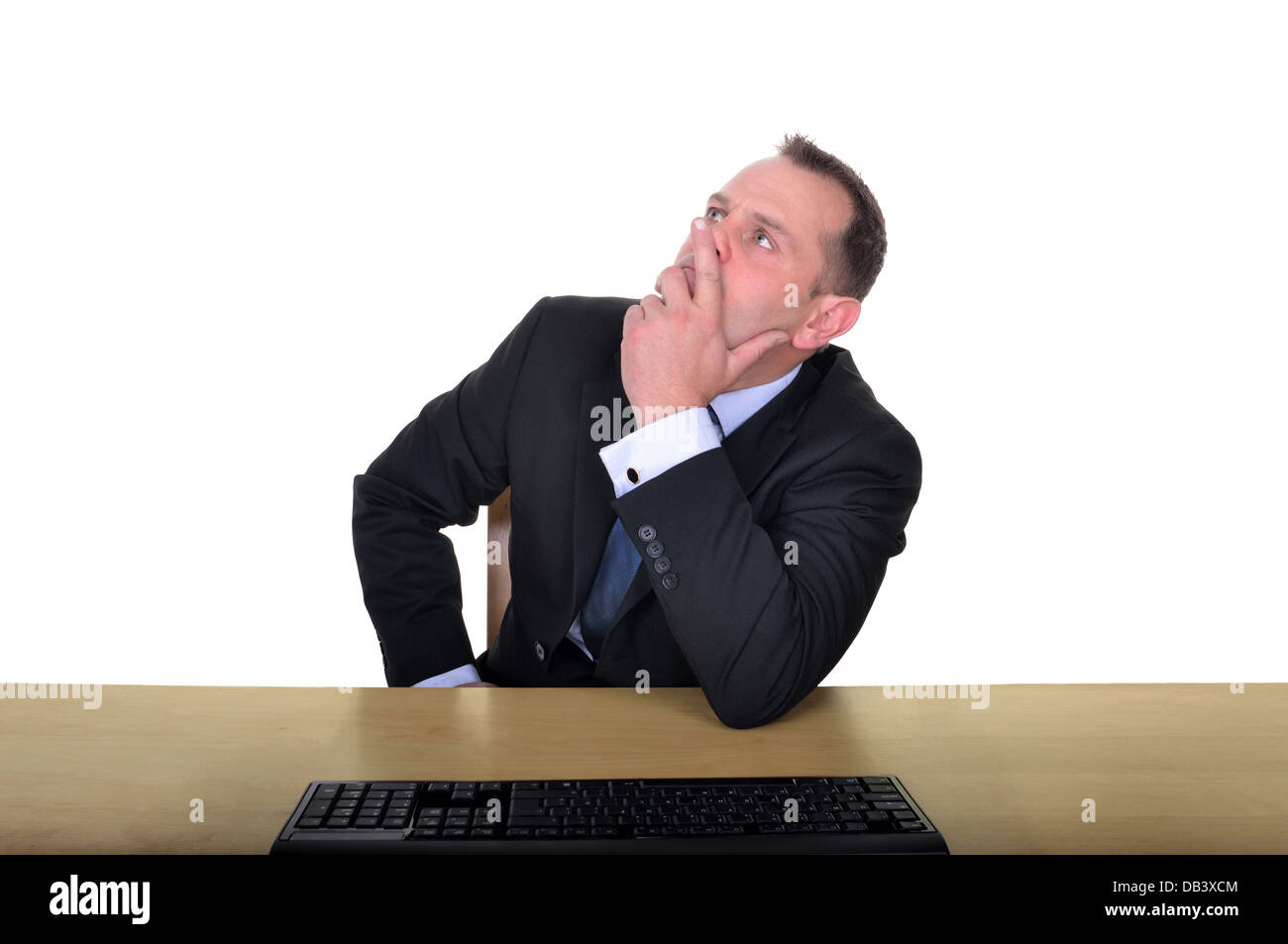 Image of a businessman sitting at a desk thinking. Stock Photo