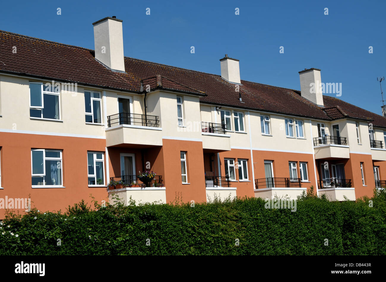 Row of terraced houses/flats against a clear blue sky. Stock Photo