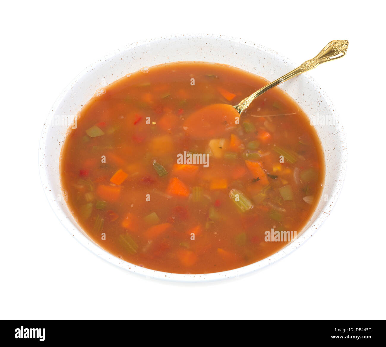 A large shallow bowl filled with crab meat stew with a gold spoon on a white background. Stock Photo