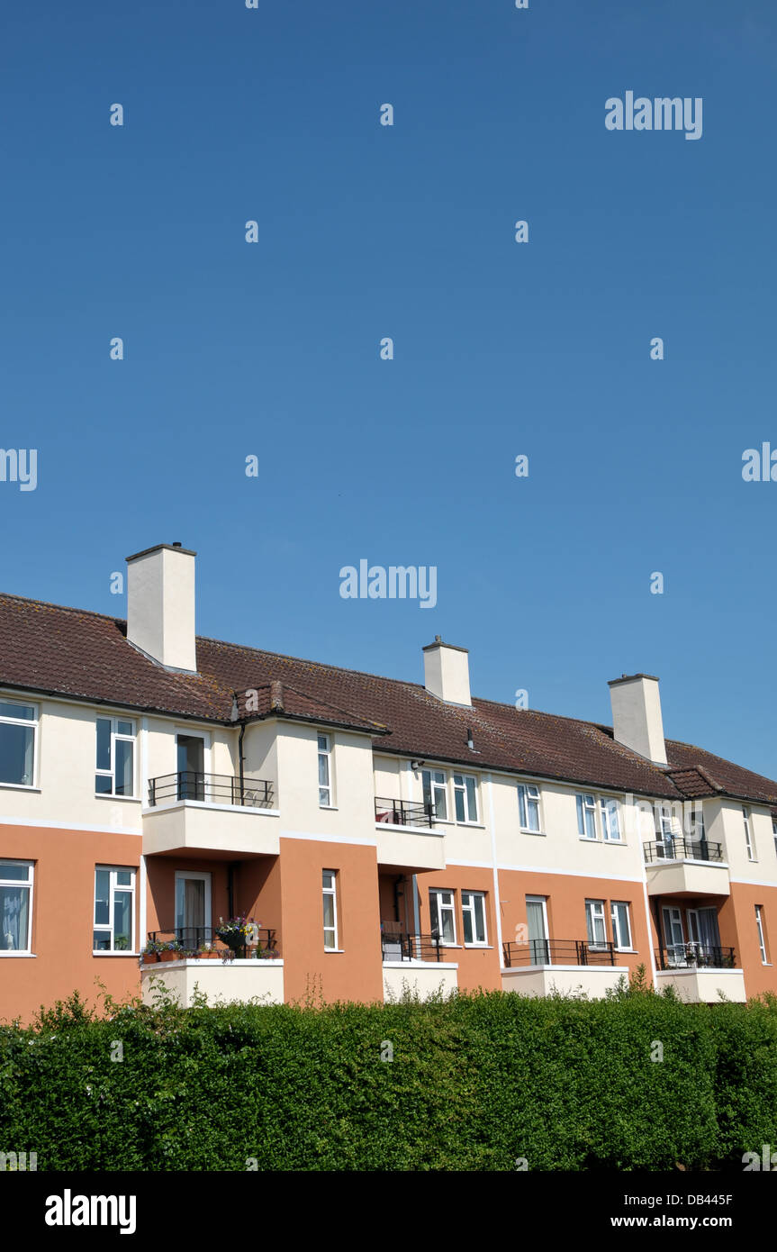 Row of terraced houses/flats against a clear blue sky. Stock Photo