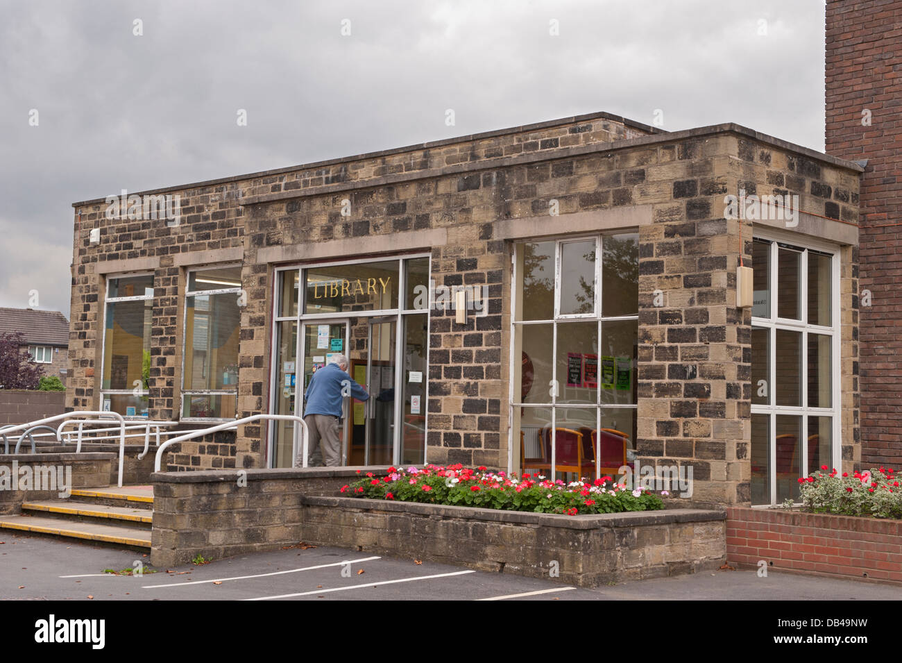 The exterior entrance doorway of Menston Library & an elderly lady is