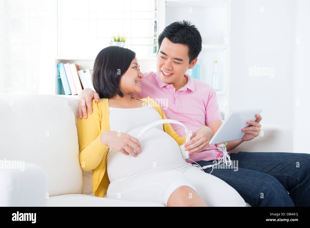 Pregnant woman putting headphones on belly Stock Photo Alamy