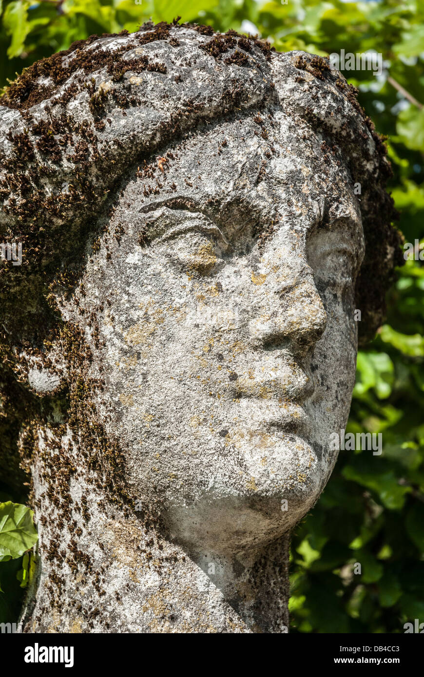 Weathered limestone figure head of garden statue. Stock Photo