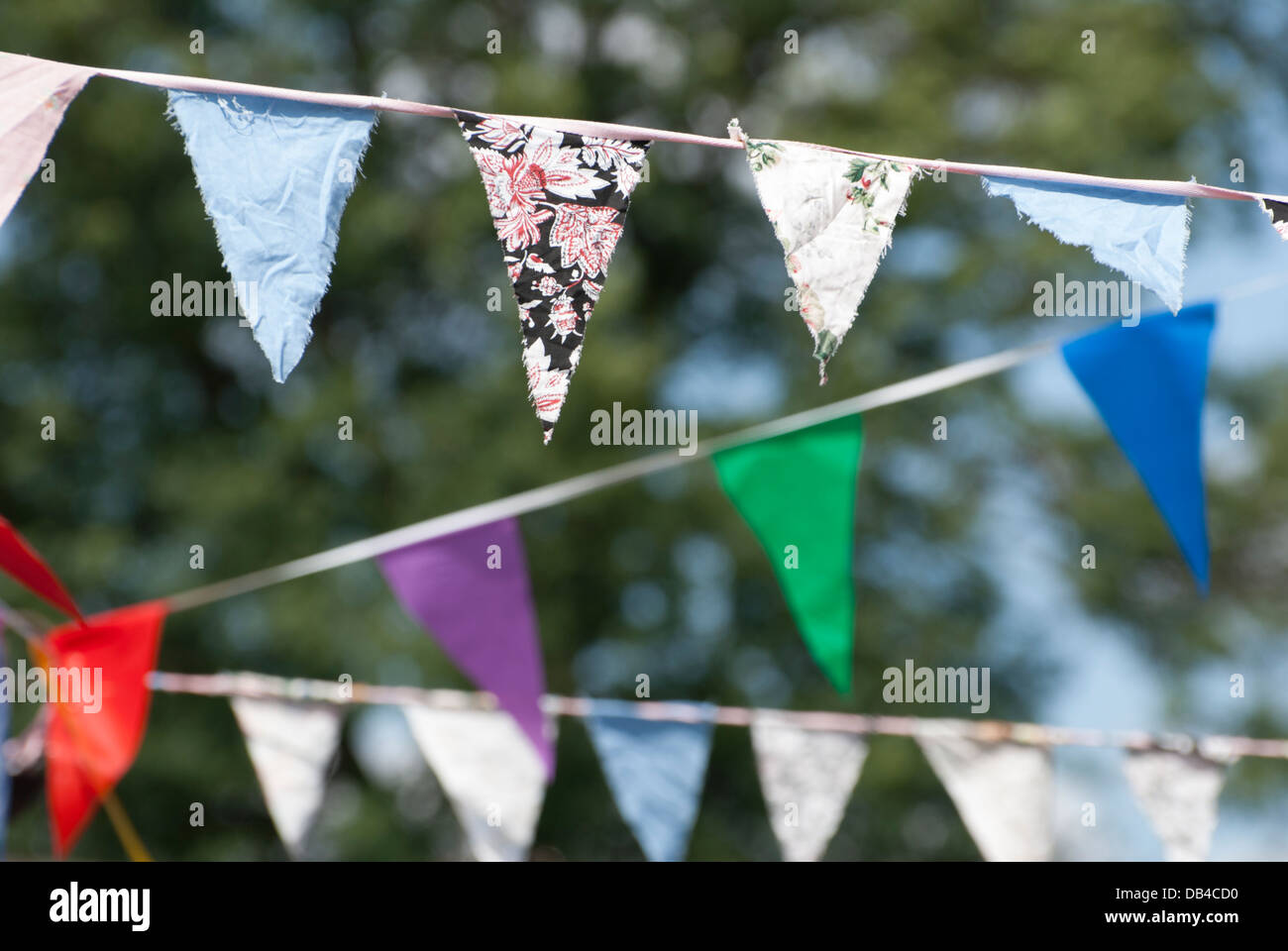 Multicolored summer Bunting flags hanging at an English garden party fete. Stock Photo