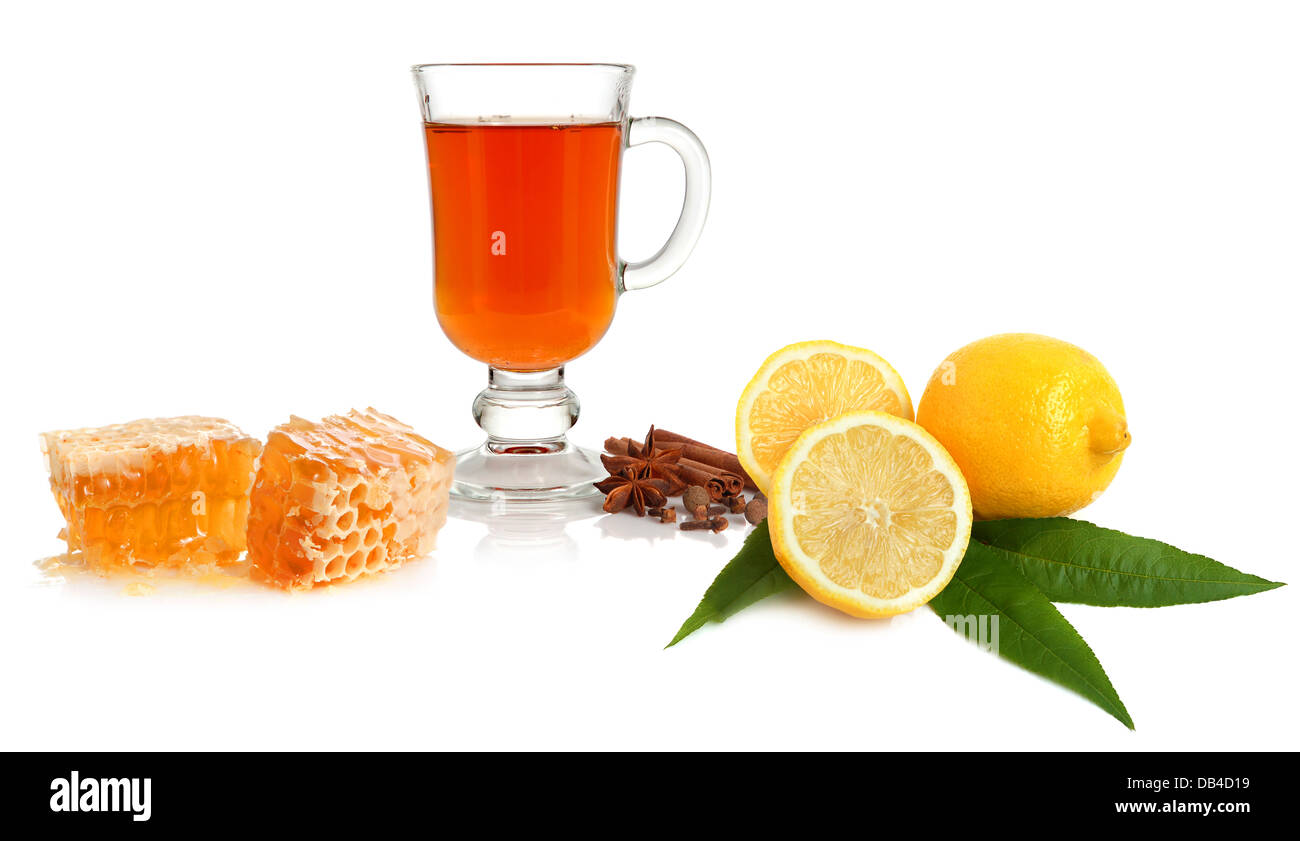 Hot tea in glass cup with spice, lemon and honey on white background