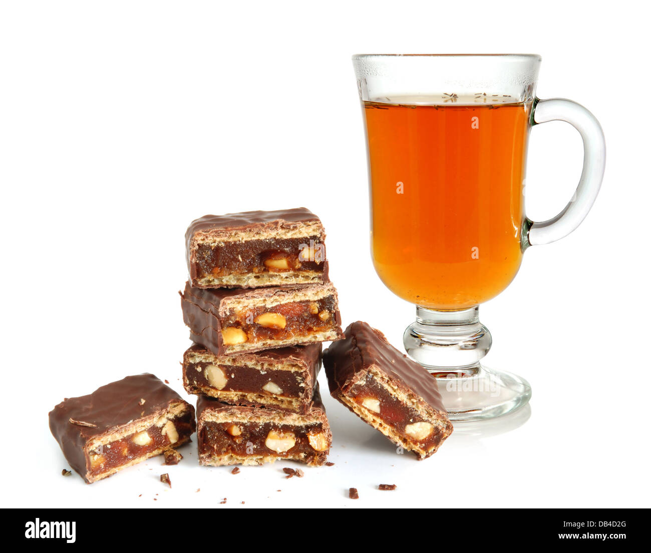 Hot tea in glass cup and broken chocolate with nuts and strawberry jam