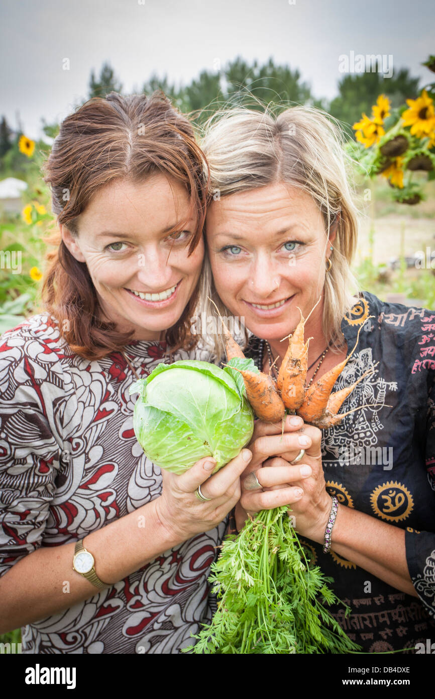 Abigail Sullivan and Kasha Rigby with some vegetables from their garden in Boulder, Utah. Stock Photo