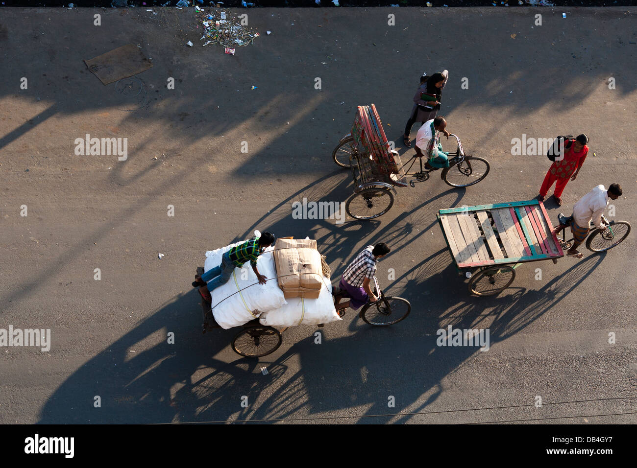 View from above of rickshaws casting shadows on the road as they ferry passengers along the streets of Chittagong Bangladesh Stock Photo