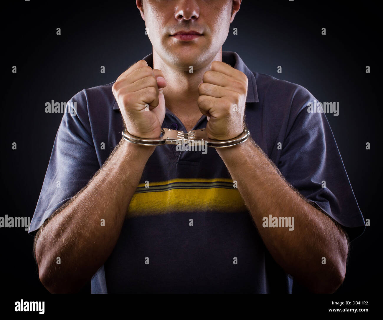 man wearing handcuffs on a black background Stock Photo