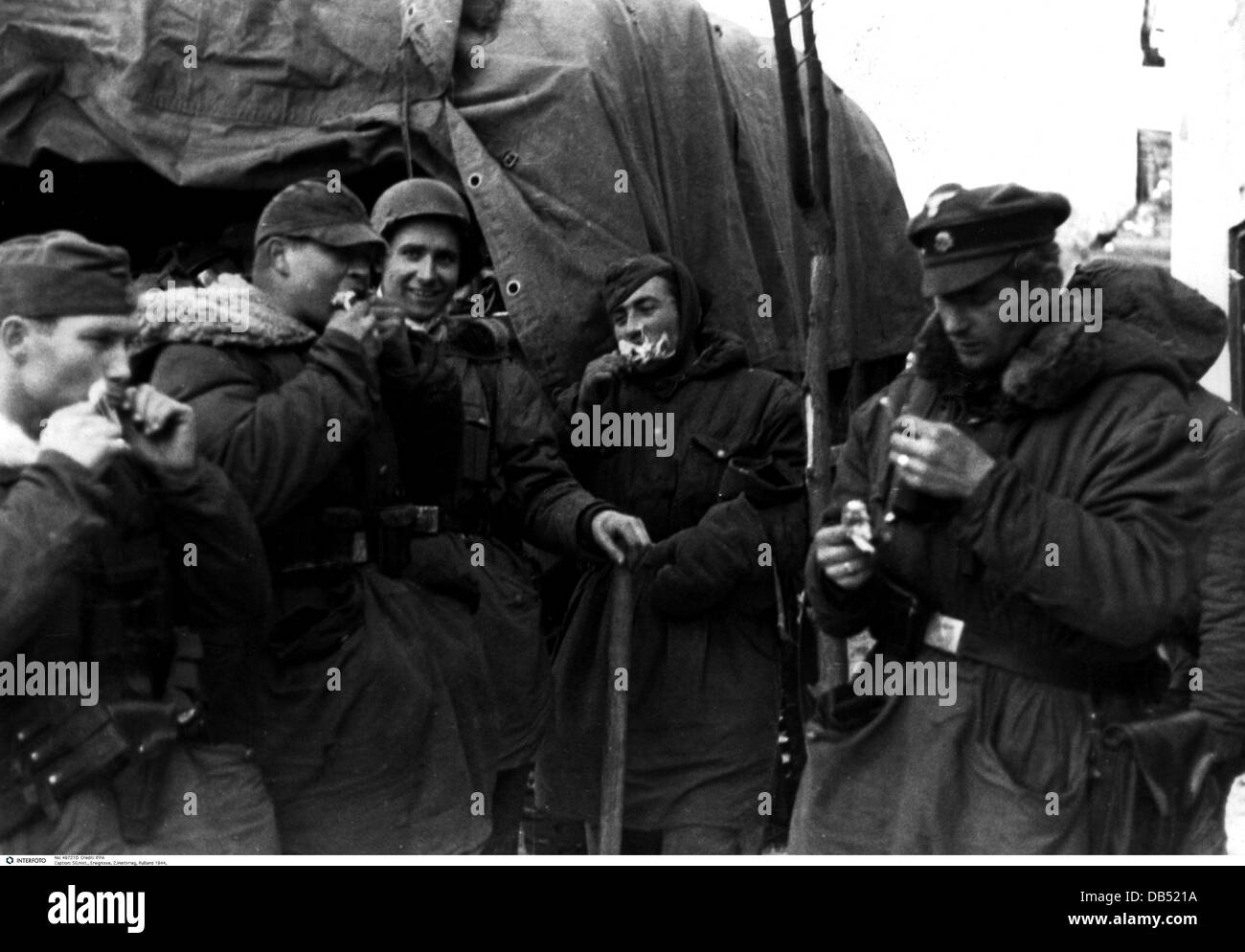events, Second World War / WWII, Russia 1944 / 1945, soldiers of the Waffen-SS having a lunch break, Britskoye, Ukraine, 15.1.1944, Eastern Front, USSR, Waffen SS, eating, roast chicken, broiler, winter clothes, clothing, 20th century, historic, historical, Wehrmacht, Army Group South, uniform, uniforms, people, 1940s, Additional-Rights-Clearences-Not Available Stock Photo