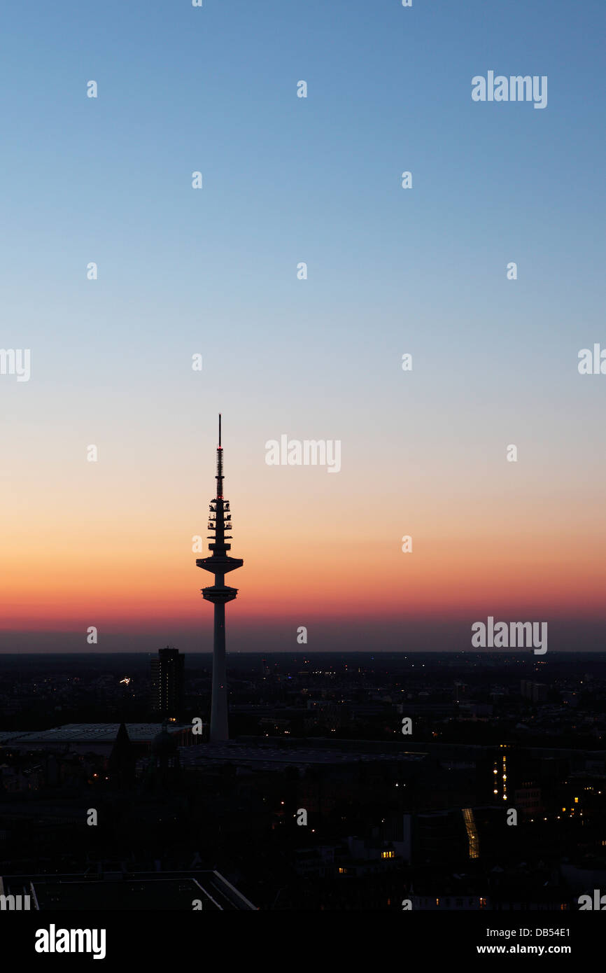 The television tower (Fernsehturm) is silhouetted at dusk in Hamburg, Germany. Stock Photo
