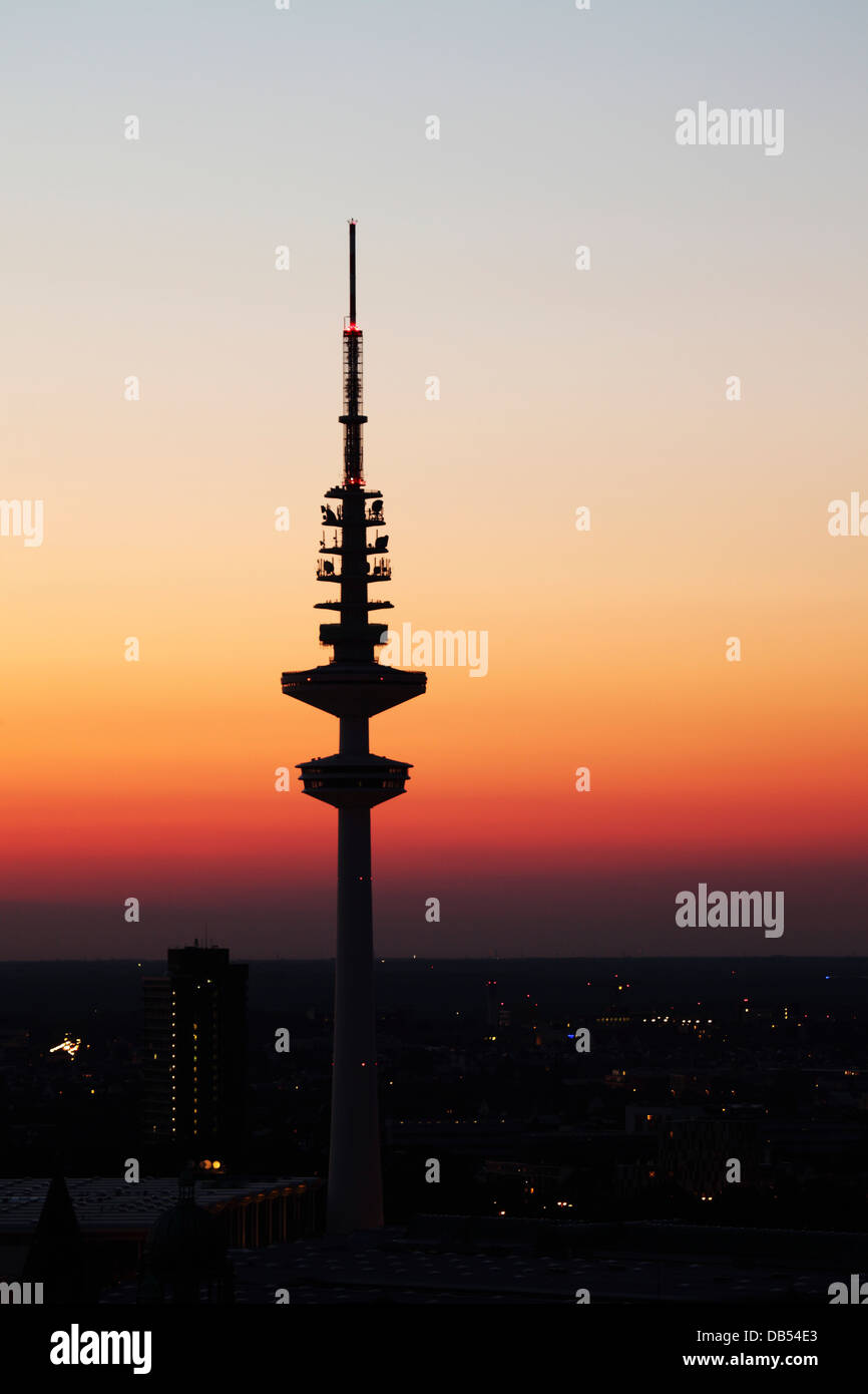 The television tower (Fernsehturm) is silhouetted at dusk in Hamburg, Germany. Stock Photo