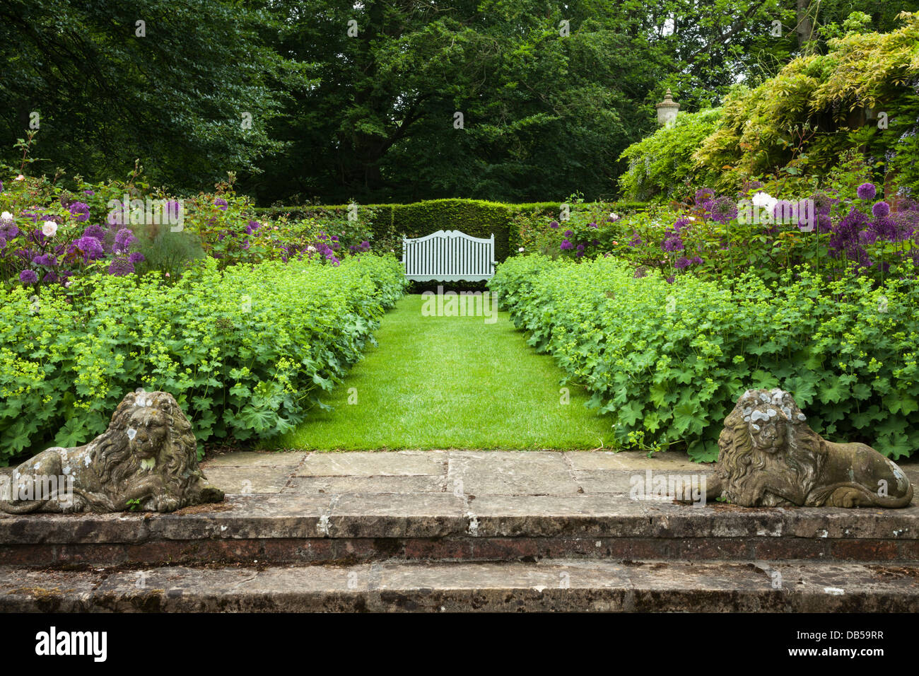 Stone steps leading to Cottesbrooke Hall's 'Philosopher's Garden' with floral borders and garden seat, Northamptonshire, England Stock Photo