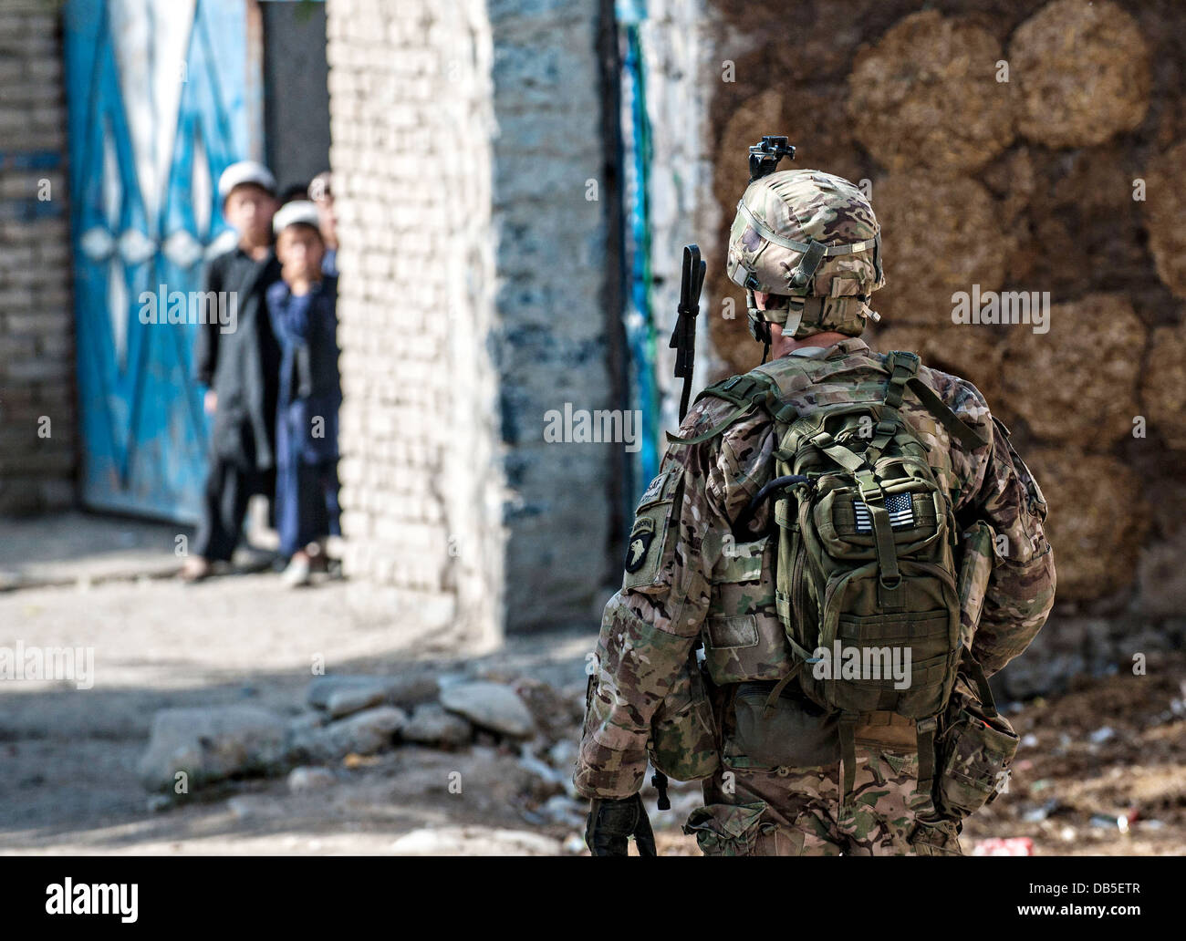 A US army soldier patrols through the streets of a village near Forward Operating Base Salerno July 4, 2013 in Khost province, Afghanistan. Stock Photo
