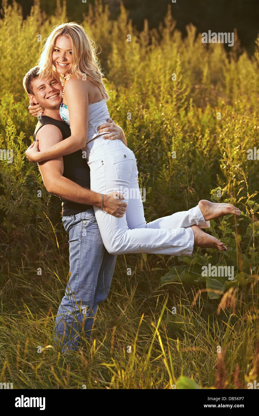 Young couple on the background of the high grass. The guy holding the ...