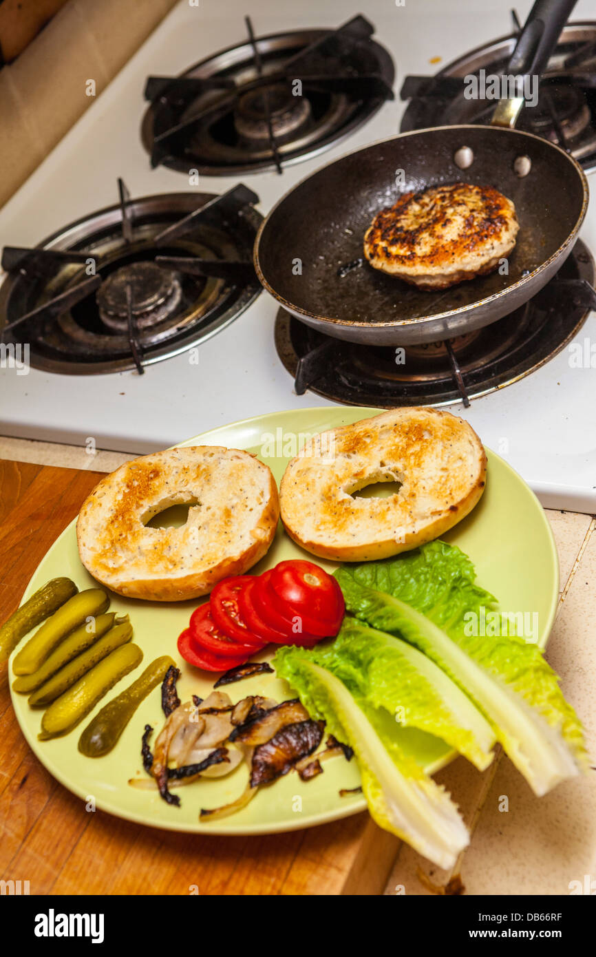 A turkey hamburger on an onion bagel with pepper jack cheese, pickles