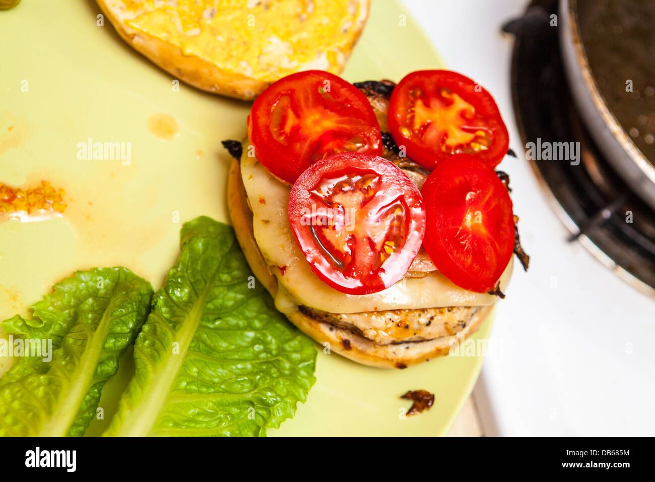 A turkey hamburger on an onion bagel with pepper jack cheese, pickles