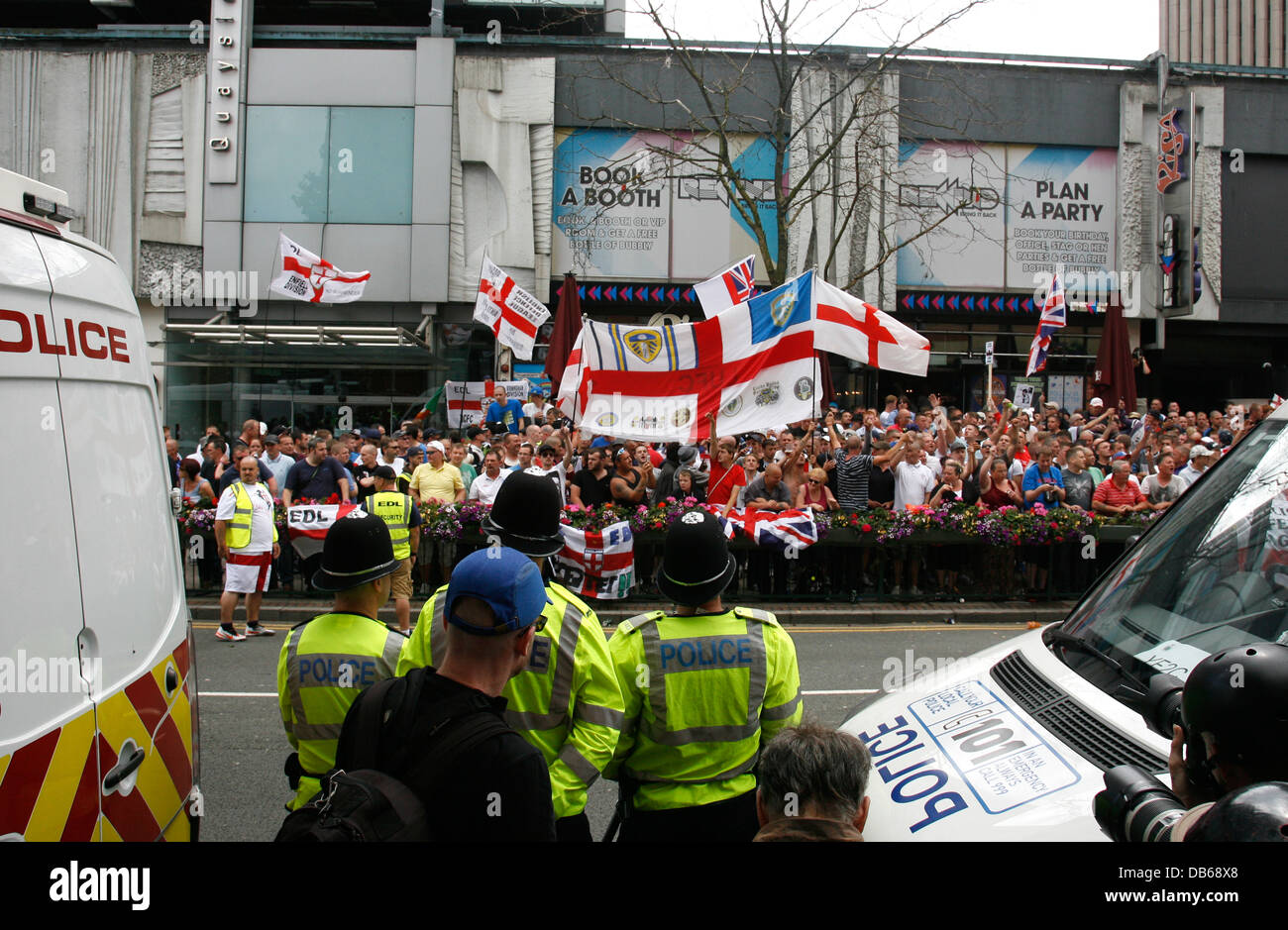 Police & photographers observe English Defence League (EDL) protesters from the opposite side of Broad street. Birmingham, July 2013. Stock Photo