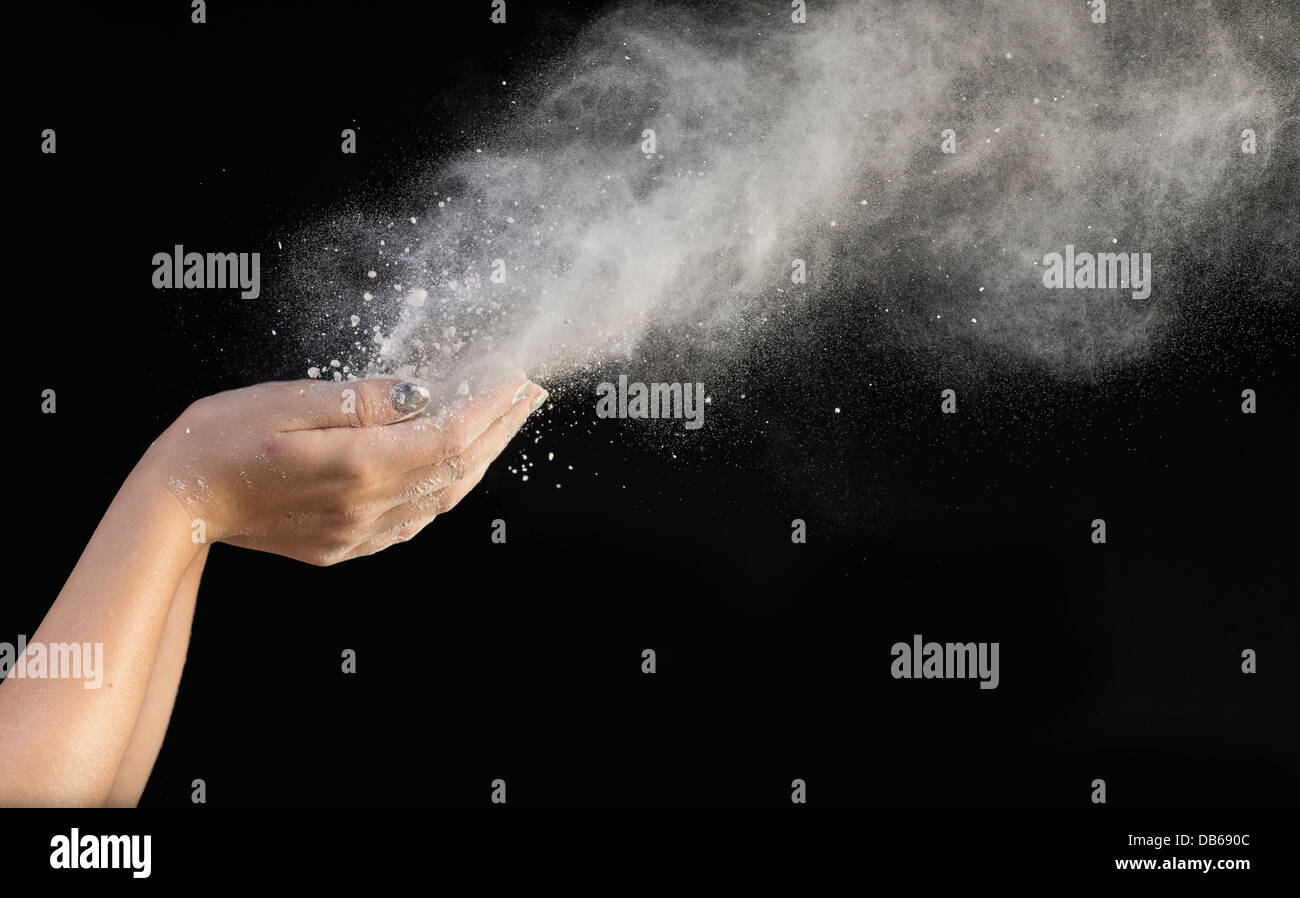 White Powder Being Blown Out Of Cupped Hands Stock Photo