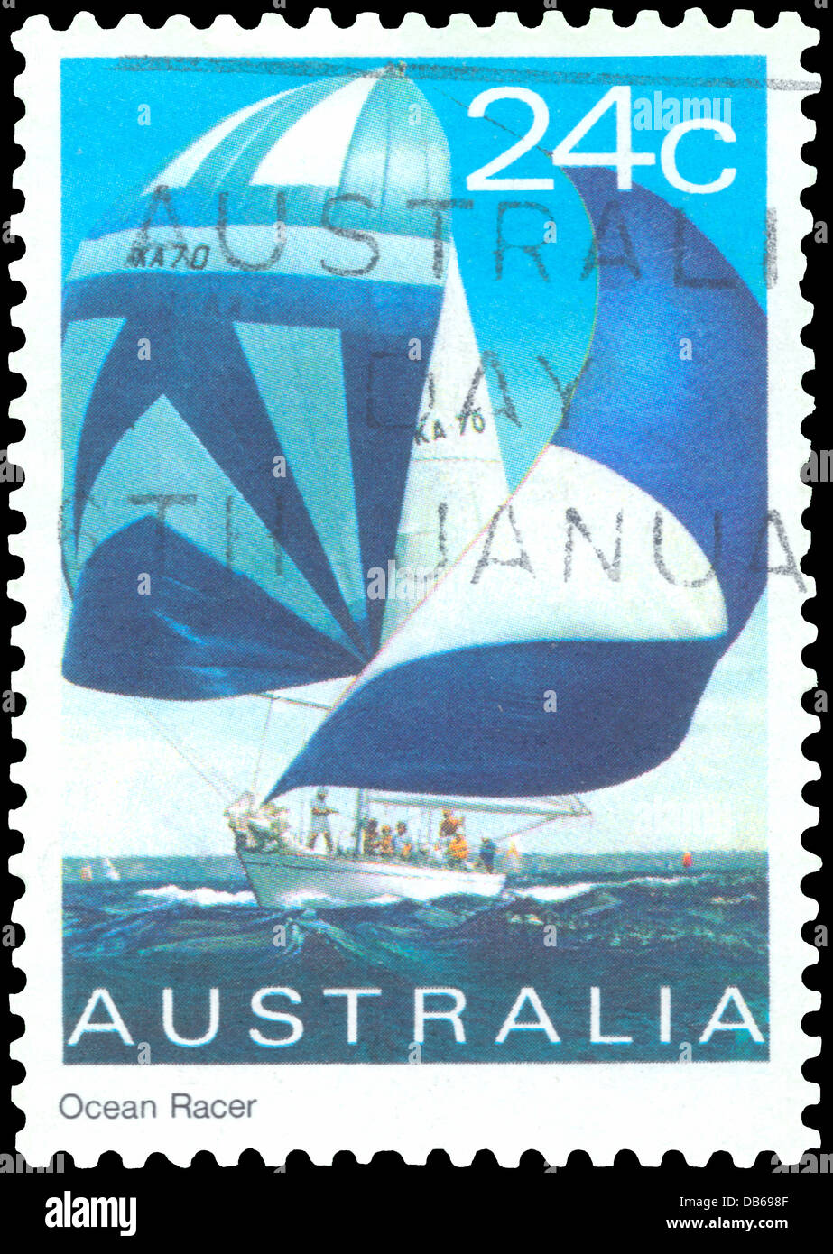 Postmarked Australian stamp titled Ocean Racer, showing a sailboat on the high seas with billowing blue and white sails. Stock Photo