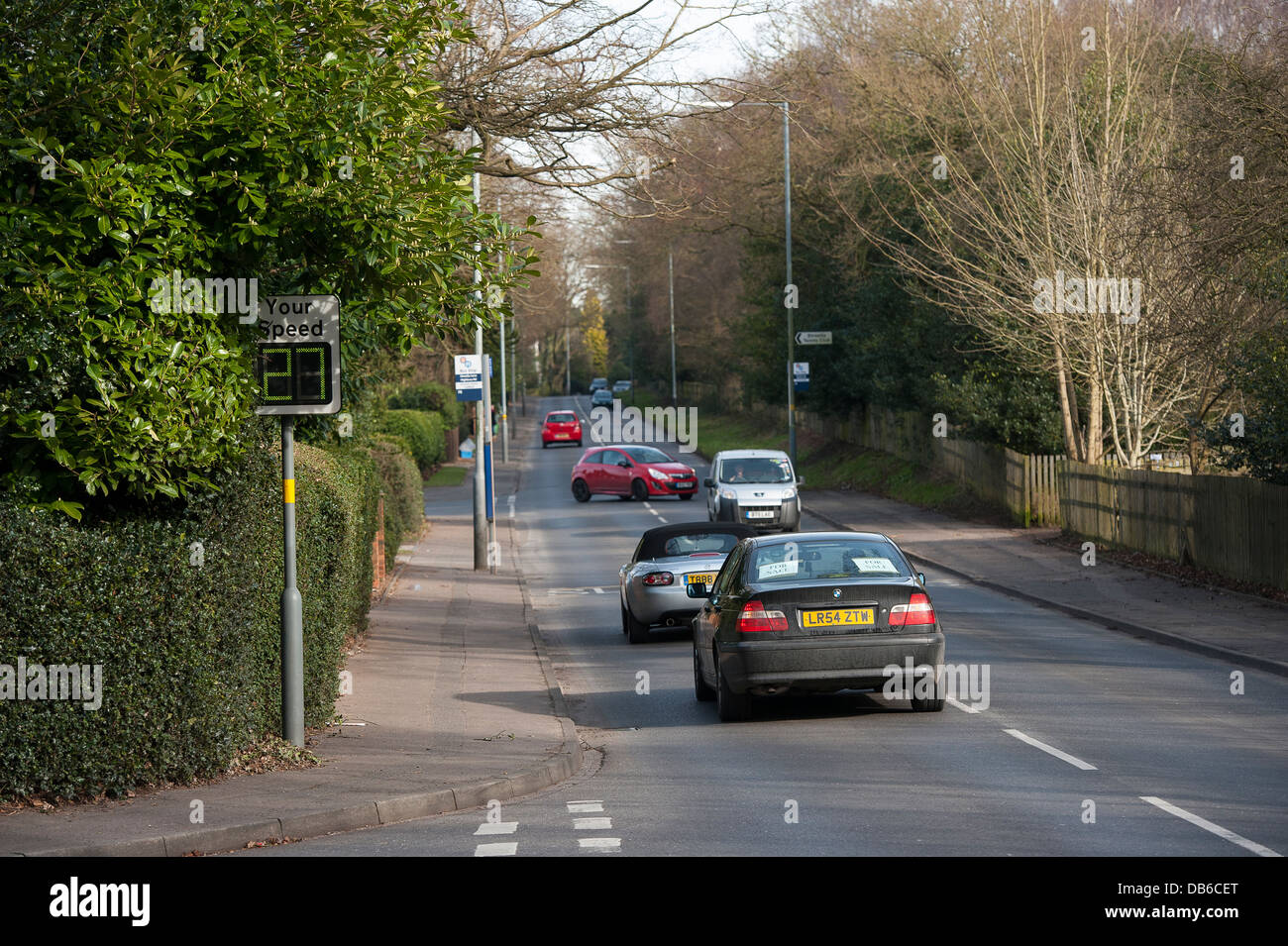 Traffic driving past a speed monitoring sign on a road in England. Stock Photo
