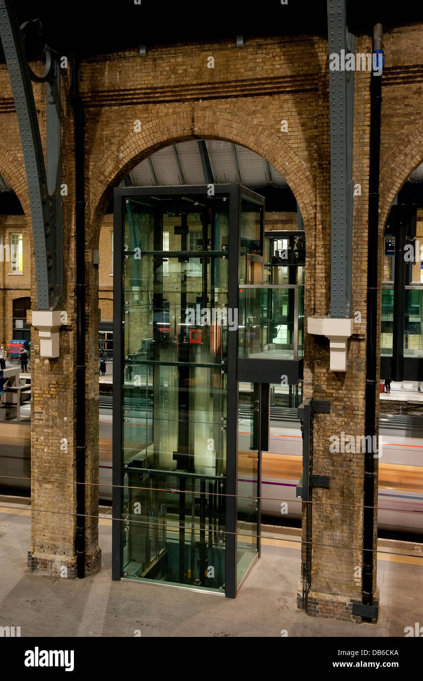 Glass lift in the platform area of Kings Cross Railway Station, London, England. Stock Photo