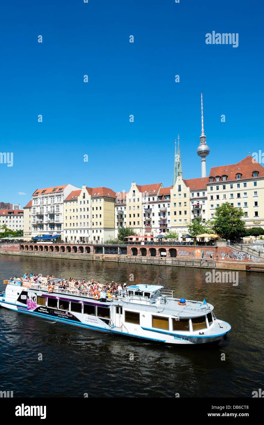 Skyline of Berlin and Spree River with tourist cruise ship at Nikolaiviertel historic district in Mitte Berlin Germany Stock Photo